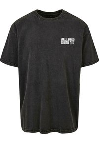 Tricou din bumbac negru, cu o croială lejeră, mâneci scurte, guler de tip crew și un grafic text frontal care spune "TOT CE AM NEVOIE ESTE UN MICROFON" în alb.