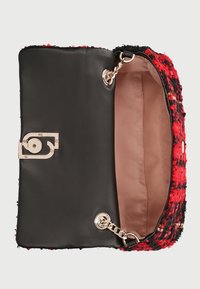 Bolso de tweed negro y rojo con cadena dorada, con cierre a presión y forro interior negro sólido.