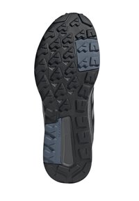 Suela de zapatilla de correr negra con un patrón de tracción resistente que presenta diferentes texturas y un bloque de acento azul para mayor agarre.