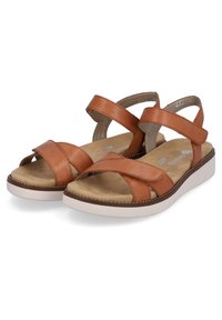 Sandales en cuir marron avec des brides croisées, une semelle rembourrée et un léger talon. Design confortable avec une semelle intérieure texturée et une semelle contrastée.