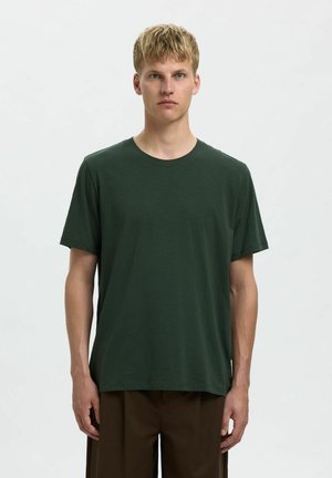 Camiseta de manga corta de color verde oscuro, hecha de un tejido suave, con cuello redondo y un corte holgado. Diseño sencillo sin patrones ni acentos visibles.