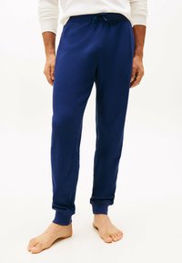 Pantaloni lounge blu navy realizzati in tessuto testurizzato, con vita elastica dotata di cordoncino e polsini aderenti.