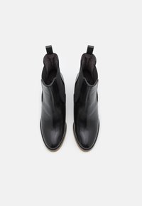 Bottes en cuir noir à cheville avec une finition lisse, des panneaux latéraux élastiques et des languettes pour un enfilage facile. Avec un bout rond et un petit talon empilé.