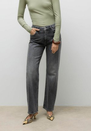 Jeans grises de cintura alta con un diseño de pierna recta, que cuentan con bolsillos delanteros y un deslavado sutil, combinados con zapatos puntiagudos con patrón.