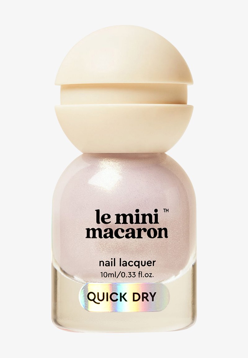 Petit flacon transparent de vernis à ongles avec un bouchon beige en forme de dôme, étiqueté "le mini macaron" et "séchage rapide" en texte noir.