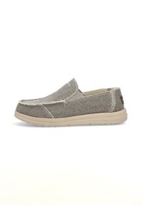Zapato tipo slip-on en tejido gris texturizado con suela de goma beige, con puntera redondeada y costuras visibles a lo largo de las costuras.