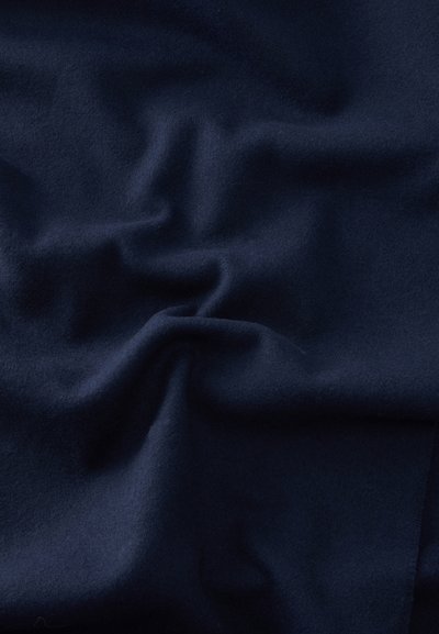Σκούρο ναυτικό μπλε ύφασμα με απαλά πτυχώσεις και υφή που δημιουργεί ήπιες σκιές και ανταύγειες.