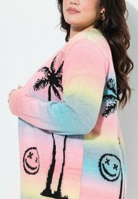 Trui gebreid in pastel gradient kleuren met ontwerpen van palmboom en lachend gezicht in zwart, met een relaxed fit en zachte textuur.