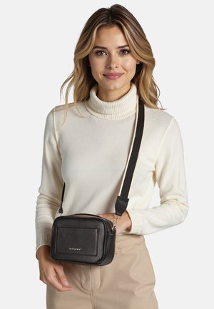Sac en bandoulière en cuir noir avec un extérieur texturé, de forme rectangulaire, fermeture éclair et bandoulière réglable. Le design minimaliste présente un logo.