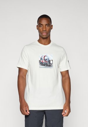 Light beige t-shirt with a round neck and short sleeves, featuring a graphic of a vehicle on the front, made from soft cotton fabric.