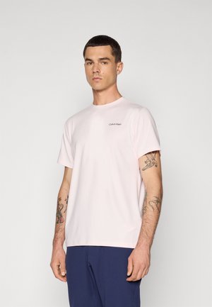 Ljusrosa kortärmad T-shirt i mjukt tyg. Har en rund halsringning och en liten Calvin Klein-logotyp i mörkgrått på vänster bröst.