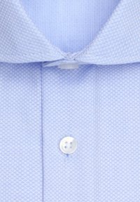 Light blue textured dress shirt with a folded collar and a white button fastened near the top.