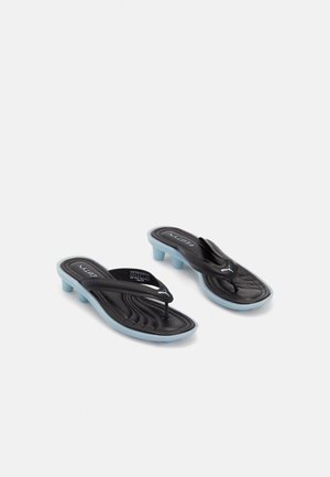 Czarne i jasno niebieskie sandały typu thong Puma Fenty z niskim obcasem i wyściełaną wkładką na białym tle.