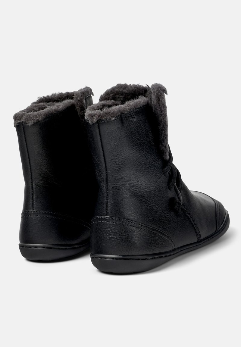 Svarta läderankelstövlar med en mjuk grå pälsfoder upptill, med en slät yta och rundad tåsdesign.