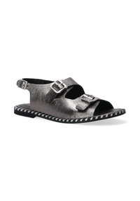 Metallisch silberne Sandale mit zwei verstellbaren Riemen und Schnallen, offenes Zehendesign und kontrastierender schwarz-weißer genähter Sohle.