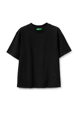 Camiseta negra de manga corta con cuello redondo, de corte holgado y una etiqueta verde en el interior del cuello.
