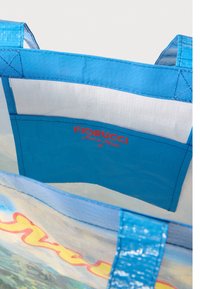 Modrá taška přes rameno s lesklou texturou, vybavená velkým oddílem a vnitřní kapsou. Logo "Fiorucci Made in Heaven" v červené barvě.