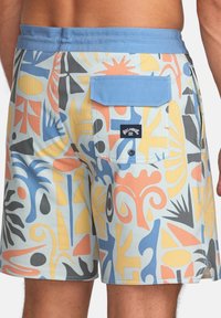 Shorts de bain en tissu bleu clair avec des motifs abstraits en orange, jaune, noir et bleu. Comprend une poche arrière avec fermeture par rabat.