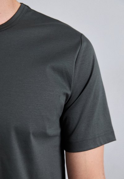 T-shirt gris foncé à manches courtes en tissu lisse, avec un col rond et des coutures nettes sans motifs ni accents supplémentaires.