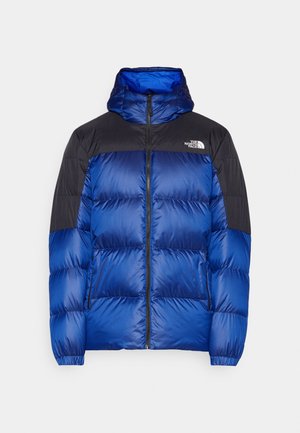Giacca puffer blu con cappuccio, con un yoke nero, motivo trapuntato, polsini elastici e zip frontale. Logo sulla parte superiore sinistra del petto.