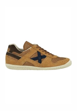 Zapatillas de ante en color beige con acentos en navy, con un diseño texturizado en la parte superior y suela de goma. Cuentan con cordones y un cuello acolchado para mayor comodidad.