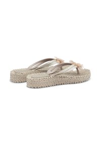 Chanclas beige de plataforma tejidas con tiras brillantes y decoraciones de flores de tela pálida sobre fondo blanco.