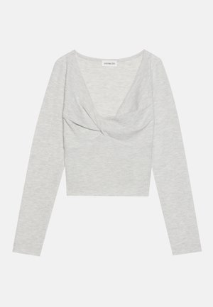 Gray long-sleeve top made of soft, textured fabric. Features a deep V-neck and a twisted front design. Cropped style with fitted sleeves.