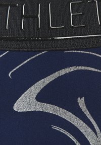 Marineblaue Sportshorts mit einem glänzenden silbernen abstrakten Muster, ausgestattet mit einem breiten schwarzen elastischen Bund mit eingeprägtem Schriftzug.