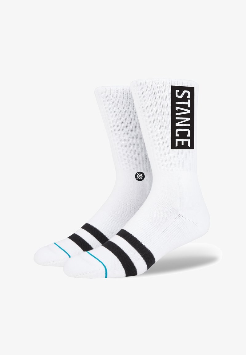 Meias brancas com textura canelada, apresentando um logo "STANCE" em preto e duas riscas pretas no punho, acentuadas por uma linha turquesa.