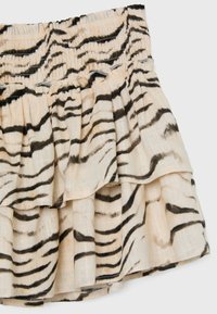 Jupe beige avec motif rayures tigre noires et taille élastique, avec des détails de tissu froncés en couches.
