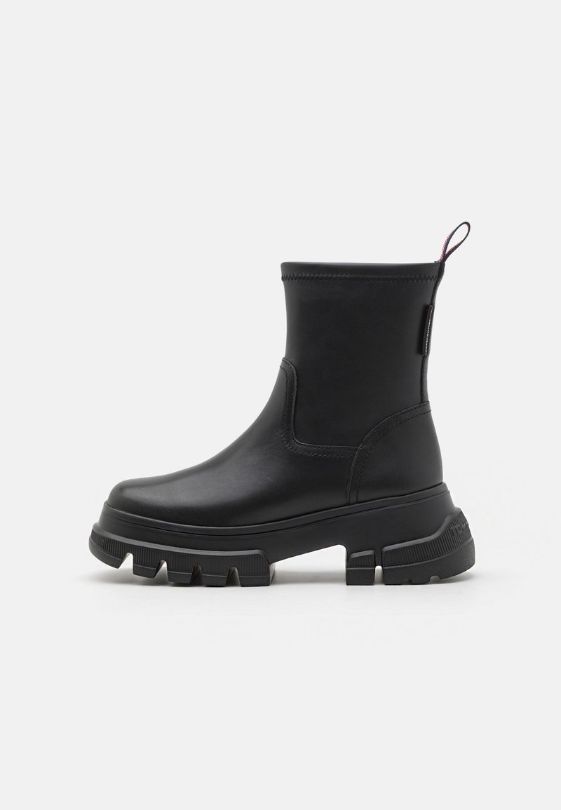Botine negre, din piele netedă, cu talpa din cauciuc masiv, vârf rotund și cârlig la spate. Design elegant, cu detalii minime.