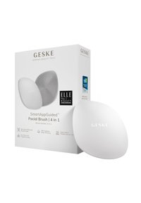 Brosse faciale GESKE SmartAppGuided, en silicone blanc, de forme ovale, avec surface texturée. La boîte comprend les détails du produit et les récompenses.