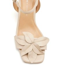Sandal con tacco alto beige con punta quadrata, caratterizzata da decorazioni a foglia in pelle stratificate sulla parte frontale e un sottile cinturino alla caviglia.