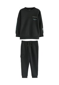 Schwarzes Sweatshirt- und Hosen-Set aus weichem Material. Mit gerippten Bündchen, bedrucktem Text und einer Cargo-Tasche auf der linken Seite der Hose.