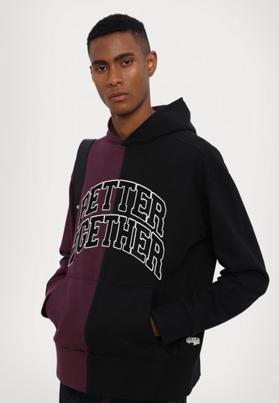 Hooded sweatshirt featuring a split design in black and burgundy with "BETTER TOGETHER" printed in white. Material appears soft, fleece-like.