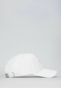 Cappellino da baseball bianco con visiera curva, fibbia metallica argentata regolabile e tessuto testurizzato. Design semplice senza motivi o decorazioni.