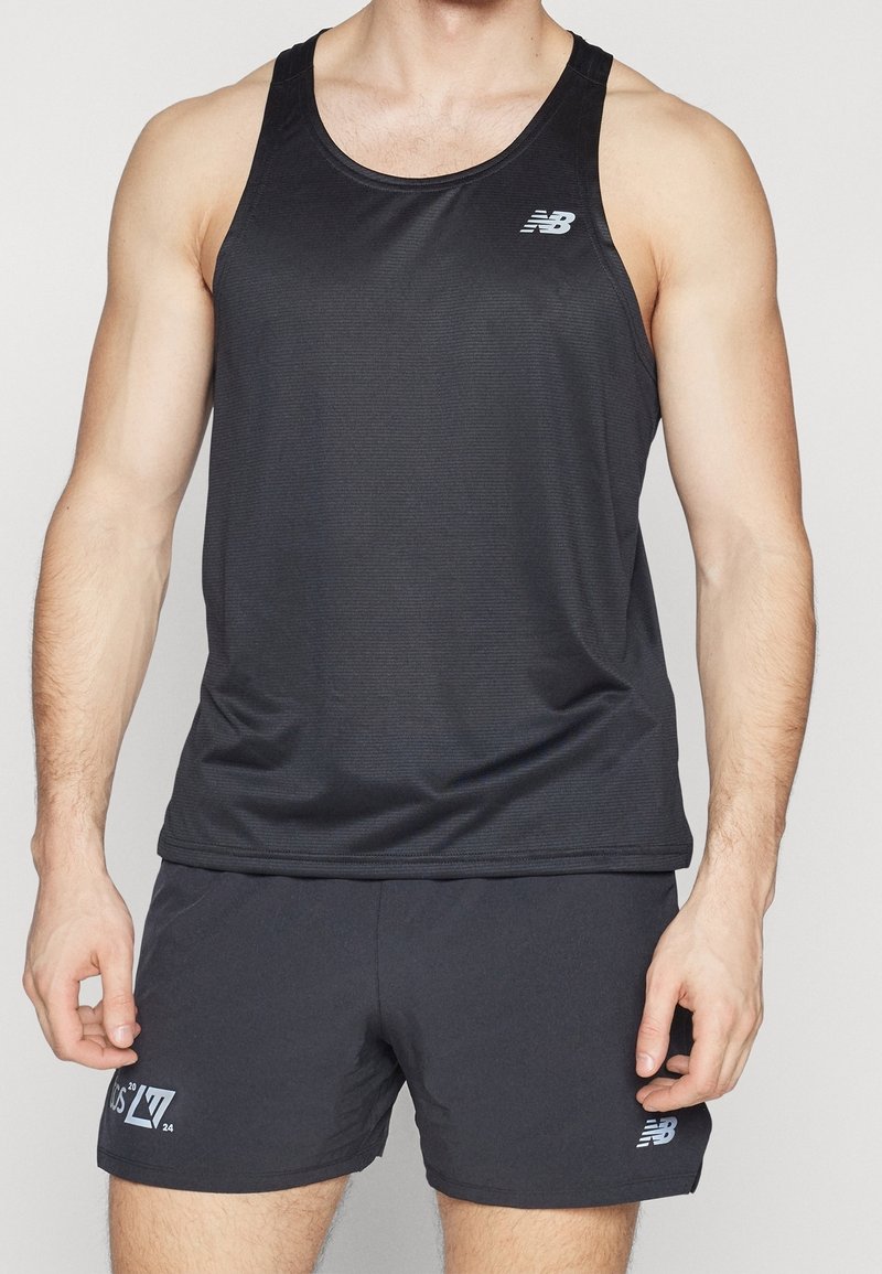 Svart atletisk linne med ribbad textur och en logotyp på vänster bröst. Matchas med svarta shorts som har en liten grafisk detalj.