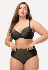 Zwart lingeriesetje met een glanzende afwerking, bestaande uit een gewatteerde bh met kantaccenten en hooggesneden slips met geschulpte randen.