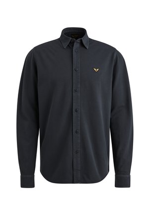 Chemise à manches longues bleu foncé avec un col button-down, des boutons sur le devant et un petit emblème doré sur la poitrine gauche. Texture de tissu lisse.