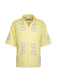 Camicetta gialla a maniche corte realizzata in tessuto con motivi a catena quadrati contornati di bianco. Chiusura frontale con bottoni e design del colletto casual.