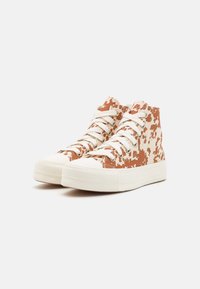 Höga sneakers med ett beige och brunt prickmönster, i bomullsmaterial, vit gummisula och plana beiga skosnören.