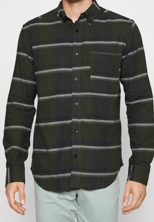 Camicia a quadri verdi con strisce grigie, dotata di colletto a punta, taschino sul petto e bottoni neri. Materiale in cotone, maniche lunghe.