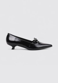 Chaussure noire en cuir verni avec un bout pointu, un petit talon et des éléments décoratifs sur le dessus. Texture lisse avec une finition brillante.