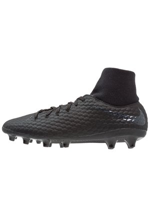 Crampon de football noir avec surface texturée, col montante à la cheville, lacets et crampons moulés pour jouer sur gazon artificiel.