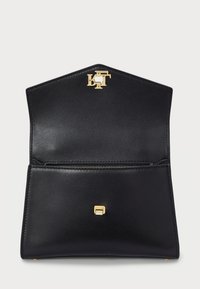 Μαύρη δερμάτινη τσάντα χειρός με δομημένο σχέδιο, διαθέτει κούμπωμα με λογότυπο σε χρυσό τόνο και εσωτερική τσέπη με φερμουάρ. Λείο υλικό, γωνιακό σχήμα.