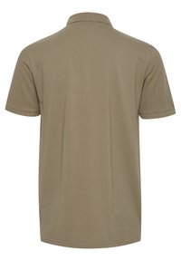 Khaki kortærmet polo-shirt med klassisk krave. Fremstillet af glat bomuld, med en subtil tekstur og uden synlige logoer eller mønstre.
