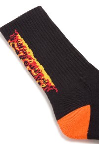 Sort bomuldsstrømpe med et lyst rødt og gult grafisk design langs siden, samt en orange tåaccent. Ribbet struktur hele vejen igennem.