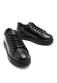 Mustade nahast sneakerid, millel on tasased paelad, kummist tallad ja kuldse "RKO"-logo detail keeles. Siledat tekstuuri koos minimaalsete augustustega.