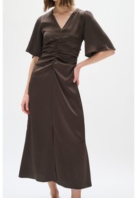 Hněd dresses střední délky s volánovými rukávy, výstřihem do V, nařasenou trupem a předním rozparkem; vyrobeno z texturované, lehké tkaniny.