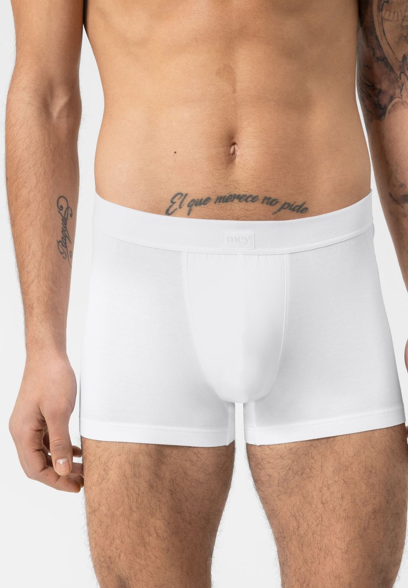 Caleçons en coton blancs avec une taille douce, un design ajusté et des coutures plates, mettant en avant une texture lisse et une couleur neutre.